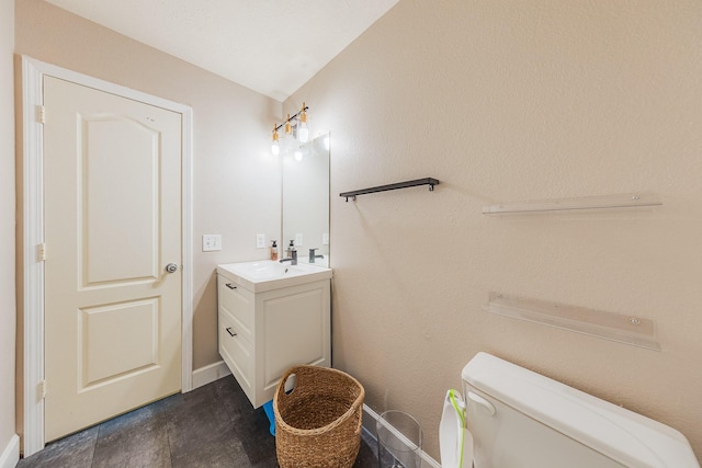 bathroom featuring vanity, lofted ceiling, and toilet