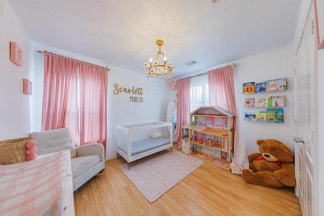 bedroom featuring wood-type flooring and a chandelier