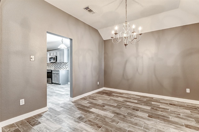 empty room featuring vaulted ceiling and a notable chandelier