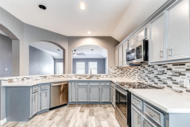 kitchen featuring stainless steel appliances, kitchen peninsula, sink, and gray cabinetry