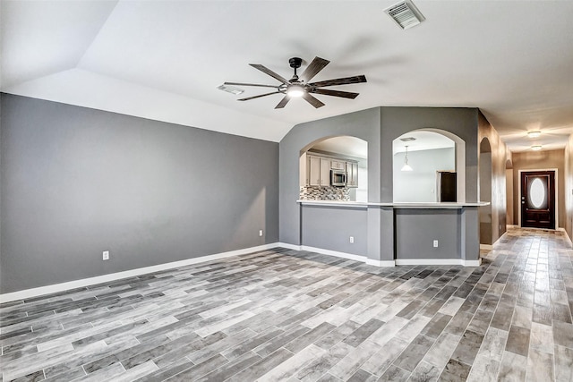 unfurnished room with ceiling fan, lofted ceiling, and wood-type flooring