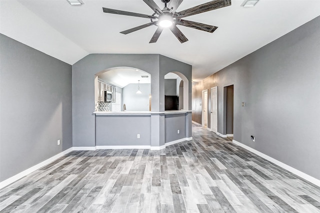 unfurnished living room featuring wood-type flooring, lofted ceiling, and ceiling fan