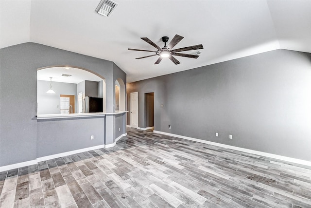 unfurnished living room featuring hardwood / wood-style flooring, lofted ceiling, and ceiling fan