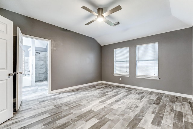 empty room with ceiling fan, lofted ceiling, and light hardwood / wood-style floors