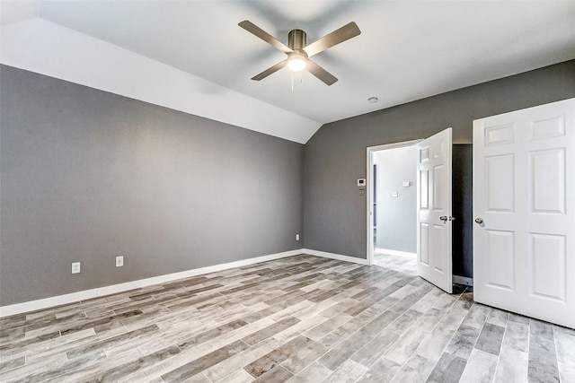 unfurnished bedroom featuring vaulted ceiling, ceiling fan, and light wood-type flooring