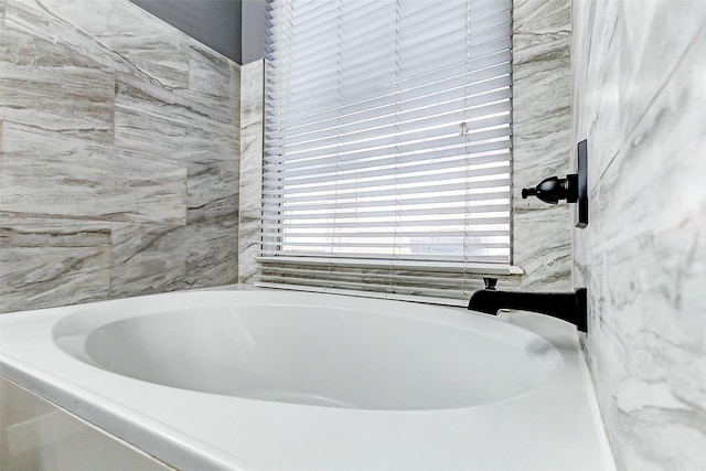 bathroom with tile walls and a bathtub