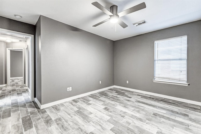 empty room with ceiling fan and light wood-type flooring