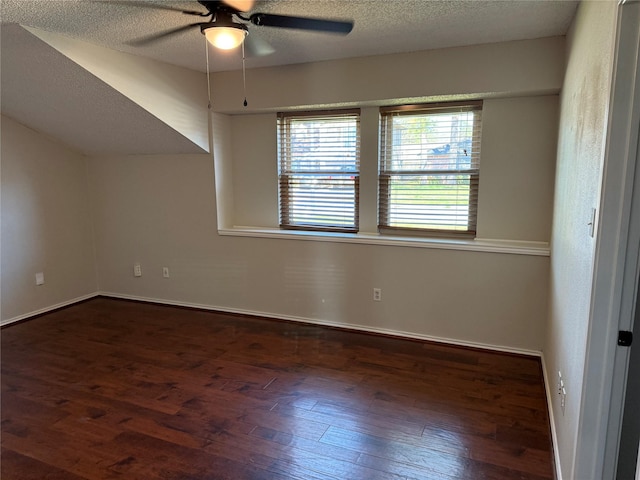 empty room featuring ceiling fan, dark hardwood / wood-style floors, and a textured ceiling