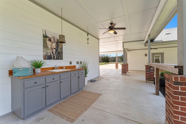 view of patio with exterior kitchen, ceiling fan, and an outdoor wet bar