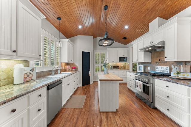 kitchen featuring a kitchen island, appliances with stainless steel finishes, butcher block countertops, white cabinets, and hanging light fixtures