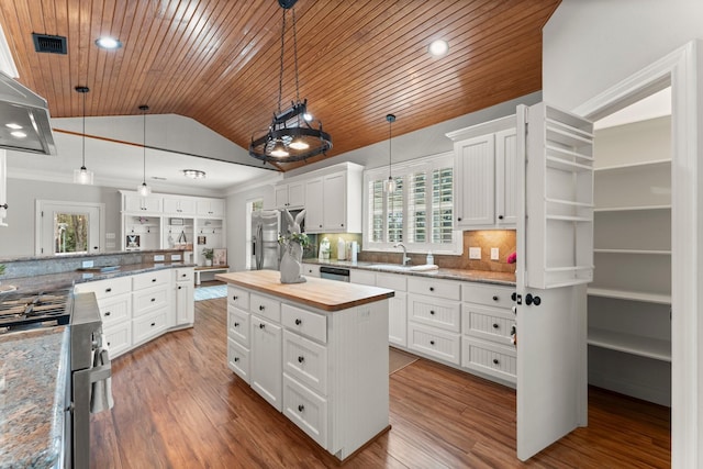 kitchen with sink, decorative light fixtures, white cabinets, and a kitchen island