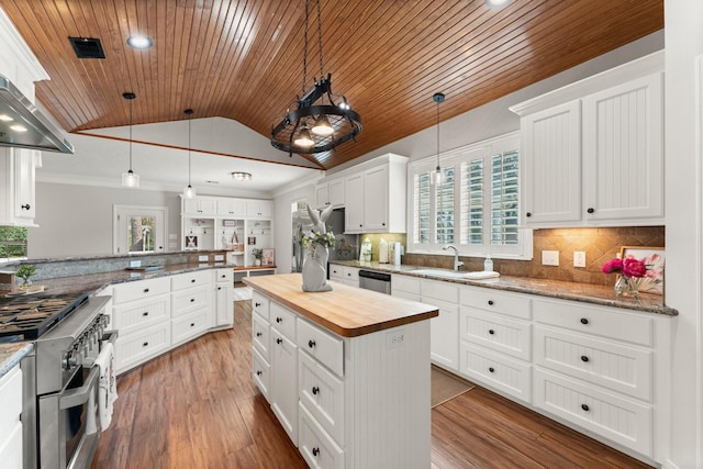 kitchen featuring stainless steel appliances, decorative light fixtures, and white cabinets