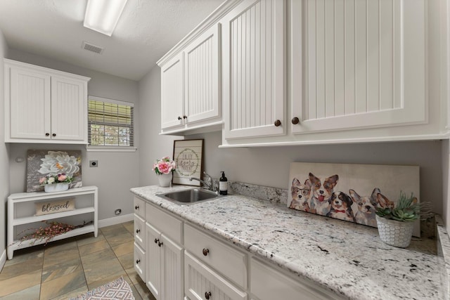 laundry room with cabinets, sink, and hookup for an electric dryer