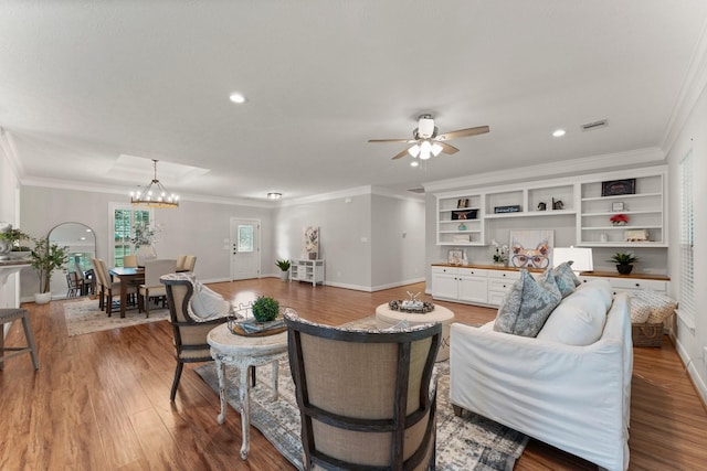 living room with crown molding, hardwood / wood-style flooring, and ceiling fan with notable chandelier