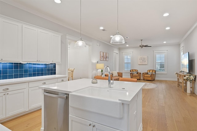 kitchen with sink, hanging light fixtures, dishwasher, a kitchen island with sink, and white cabinets