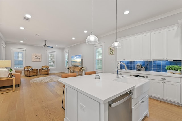 kitchen with decorative light fixtures, white cabinetry, ornamental molding, a kitchen island with sink, and stainless steel dishwasher