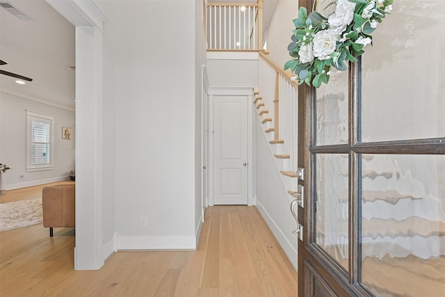 foyer featuring crown molding and light hardwood / wood-style flooring