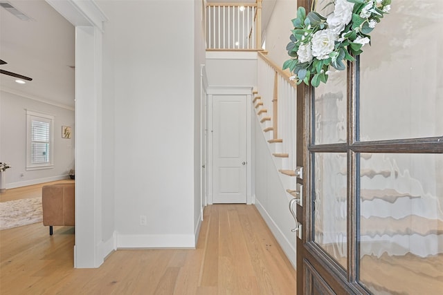 11 Caravelle Ct, Galveston, TX 77554 - entrance foyer with wood finished floors, ornamental molding, baseboards, stairway, and a ceiling fan