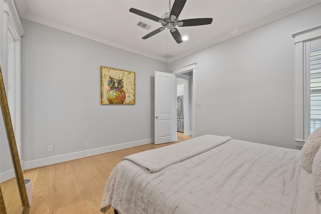 bedroom featuring multiple windows, ornamental molding, light hardwood / wood-style floors, and ceiling fan