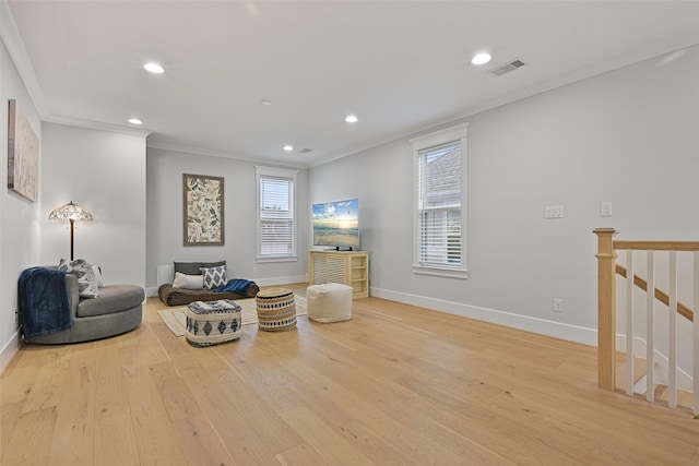 sitting room featuring crown molding and light hardwood / wood-style floors