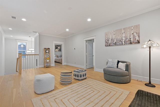 living area with crown molding and hardwood / wood-style floors