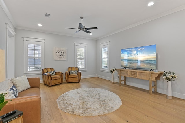 living area featuring ornamental molding, wood-type flooring, and ceiling fan