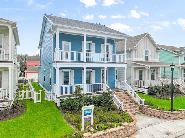 view of front facade with a porch, a balcony, and a front lawn