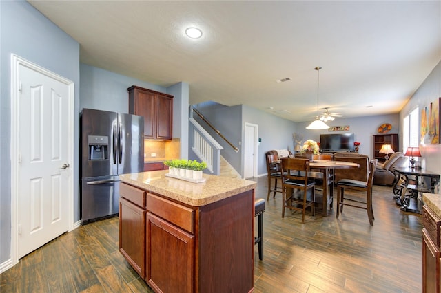 kitchen with dark wood-type flooring, a center island, open floor plan, and stainless steel refrigerator with ice dispenser