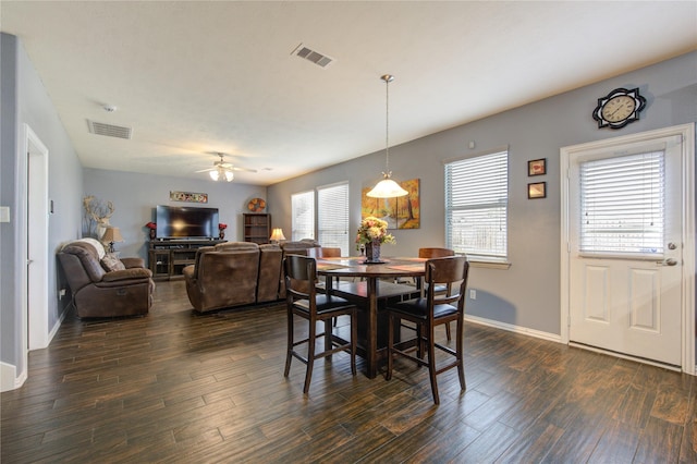 dining area featuring dark wood-style flooring, visible vents, and a healthy amount of sunlight