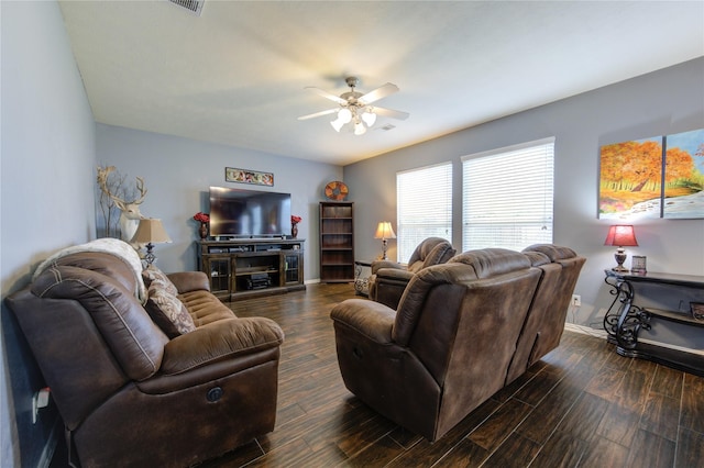 living area featuring ceiling fan, visible vents, baseboards, and dark wood-type flooring