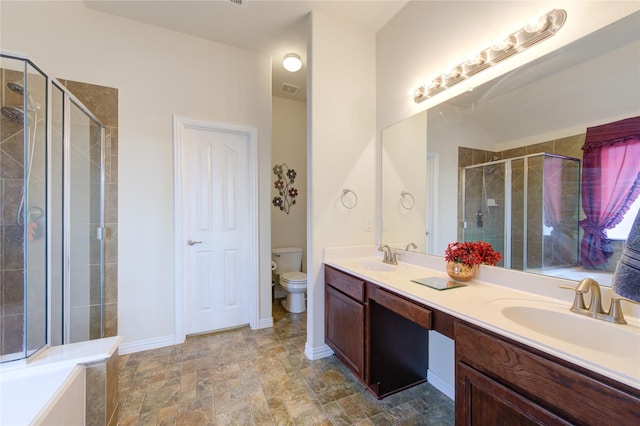 bathroom featuring baseboards, a sink, toilet, and double vanity