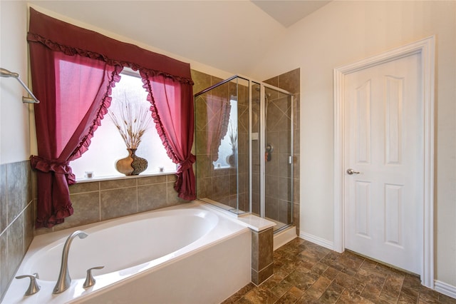 full bath with lofted ceiling, baseboards, a shower stall, a bath, and stone finish floor