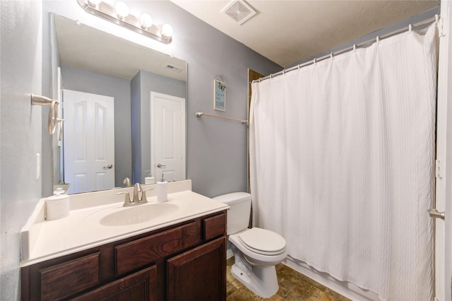 full bath featuring toilet, vanity, and visible vents