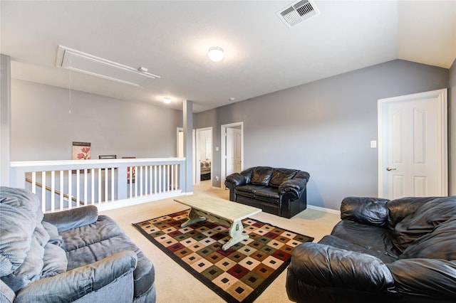 living room with attic access, visible vents, vaulted ceiling, and carpet flooring