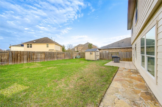 view of yard with a fenced backyard, a patio, an outdoor structure, and a storage unit