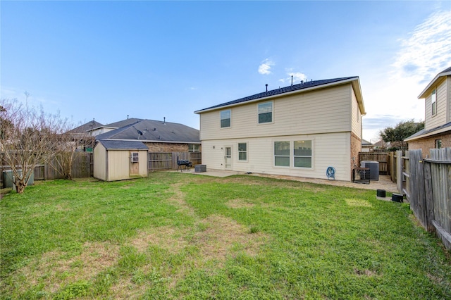 back of property with an outbuilding, a patio, a fenced backyard, a yard, and a shed