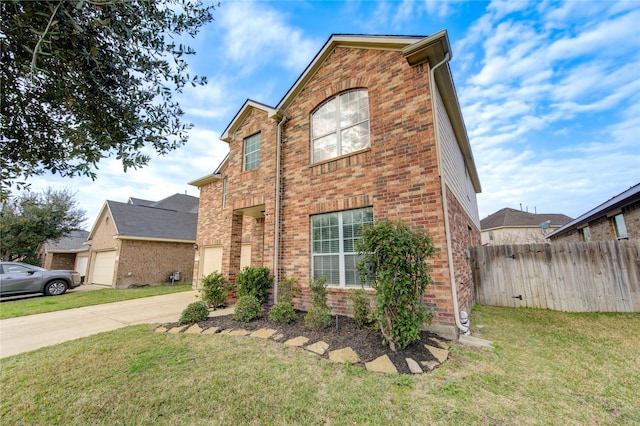 view of front of home featuring concrete driveway, brick siding, a front yard, and fence