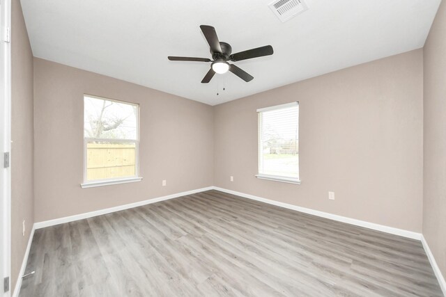 5879 Belcrest St, Houston, TX 77033 - unfurnished room with plenty of natural light, wood finished floors, and ceiling fan