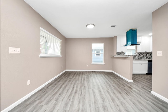 5879 Belcrest St, Houston, TX 77033 - unfurnished living room featuring light wood-type flooring and healthy amount of natural light
