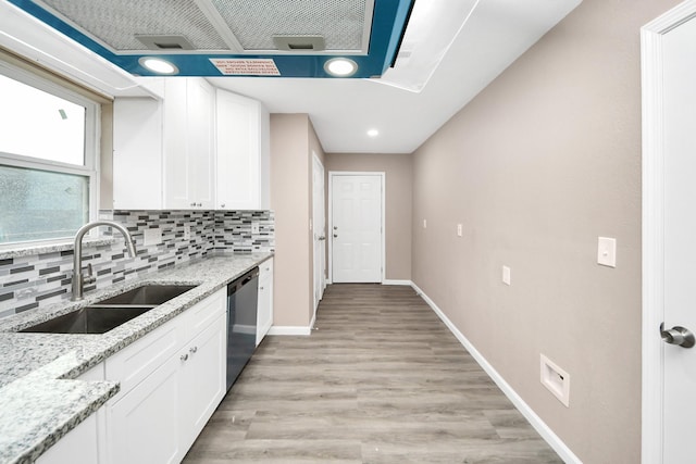 5879 Belcrest St, Houston, TX 77033 - kitchen with stainless steel dishwasher, white cabinets, backsplash, light stone countertops, and light wood-type flooring
