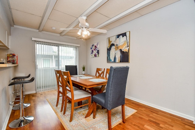 dining area featuring beam ceiling, light hardwood / wood-style flooring, and ceiling fan