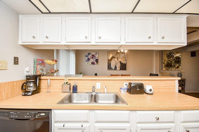 kitchen featuring dishwasher, sink, kitchen peninsula, and white cabinets