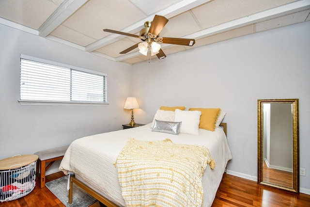 bedroom with dark wood-type flooring, ceiling fan, and beam ceiling