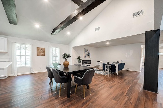 dining space with high vaulted ceiling, dark hardwood / wood-style floors, and beam ceiling