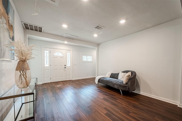 entryway with dark wood-type flooring and a textured ceiling