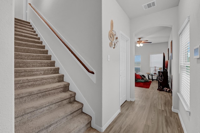 staircase featuring ceiling fan and wood-type flooring