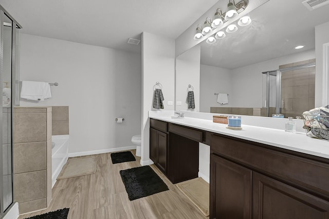 full bathroom featuring vanity, hardwood / wood-style floors, independent shower and bath, and toilet