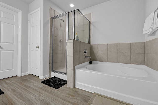 bathroom featuring hardwood / wood-style flooring and separate shower and tub