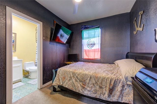 bedroom featuring ceiling fan, light colored carpet, and ensuite bathroom