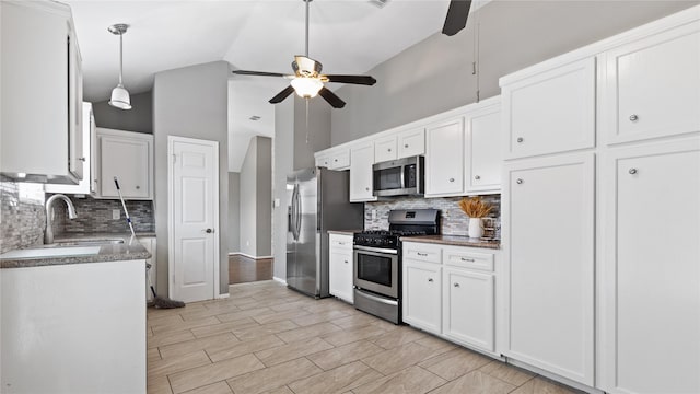 kitchen with appliances with stainless steel finishes, pendant lighting, white cabinetry, sink, and ceiling fan